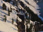 The steep slopes of the crater have rocks jutting from the snow-covered sides.