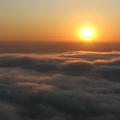 From Glacier View, the sun creates a golden sunset as it drops into a sea of clouds.