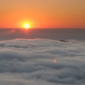 From Glacier View, the sun creates a golden sunset as it drops into a sea of clouds.