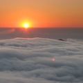 From Glacier View, the sun creates a golden sunset as it drops into a sea of clouds.