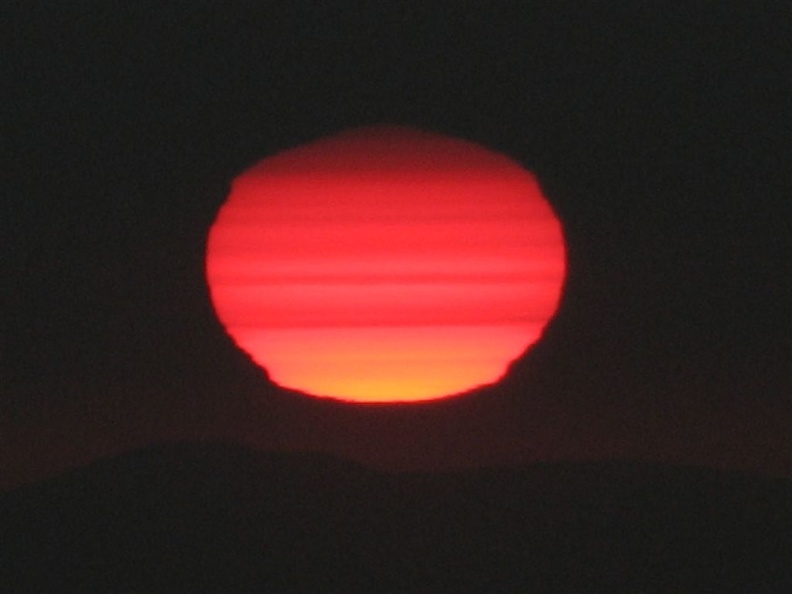 The sun is a ball of fire as it burns through the fog at sunset. This was a most incredible sunset from Glacier View.