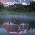 Mist on a pond reflects the image of Mt. Rainier near sunset.