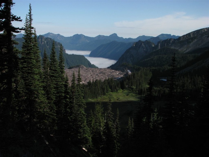 The big patch of dirt in the middle of the photo is the Carbon Glacier covered with rocks and dirt from Mt. Rainier. Fog lies in the Carbon River Valley far below.