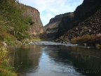 A side trail drops down to the Crooked River. A deep pool of water eddies beside the trail.