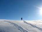 Megan snowshoes towards the sun seemingly to head to the top of the world.