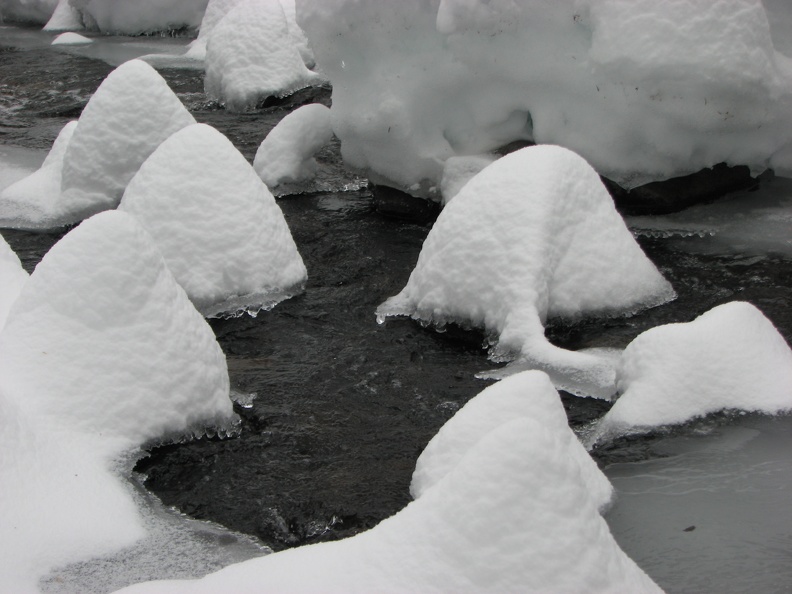 The snow makes little hats on the rocks.