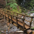 A log bridge spans Ramona Creek just downstream from Ramona Falls, providing a front-row view of the falls.