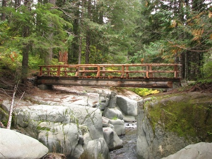 A strong steel beam bridge trimmed with wood provides an easy crossing for the Wonderland Trail over Stevens Creek.