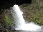 Walking under the overhanging cliff at Ponytail Falls on Horsetail Creek in the Columbia River Gorge.