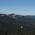 A forested and snow covered ridge of hills looking east from above Frosty rocks on the shady side of the ridge. This is on a promontory west of the Pacific Crest Trail between Barlow Pass and Twin Lakes.