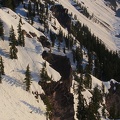 The steep slopes of the crater have rocks jutting from the snow-covered sides.