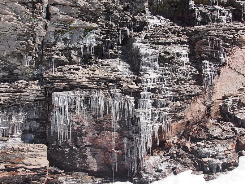 It looks like icicles form on this rock wall every evening and  melt off every sunny day.