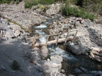 A small log bridge crosses the Inter Fork of the White River on Emmons Glacier View Trail.