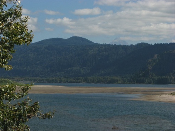 A slough of the Columbia River provides a serene foreground for the mountains in Oregon. A rocky Mt. Hood can be seen poking out in the background.