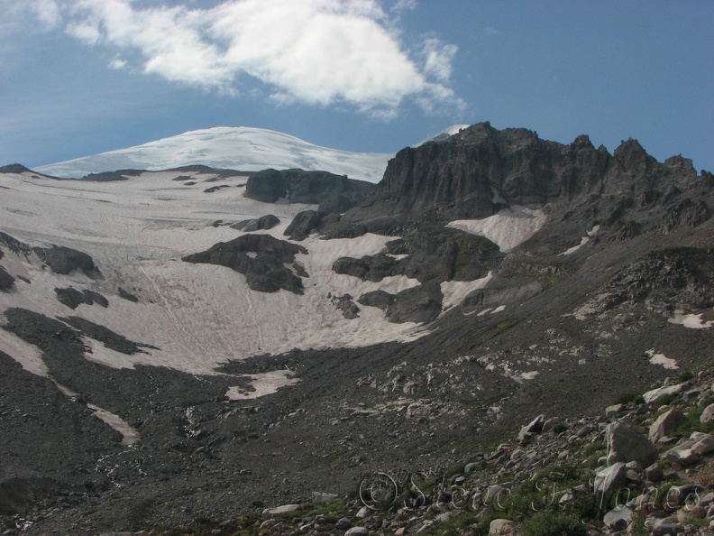The summit of Mt. Rainier peeks out from the slopes of Glacier Basin.