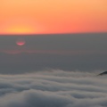 From Glacier View, the sun disappears into a fog bank and then shines through the fog above a sea of clouds.
