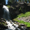 Plaikni Falls shoots down the cliff and then tumbles down a stony stream bed.