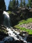 Plaikni Falls shoots down the cliff and then tumbles down a stony stream bed.