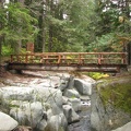 A strong steel beam bridge trimmed with wood provides an easy crossing for the Wonderland Trail over Stevens Creek.