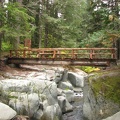 A strong steel beam bridge trimmed with wood provides an easy crossing for the Wonderland Trail over Stevens Creek.