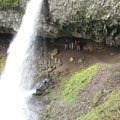 Tori, Tom, Teresa, Steve, Drew, Bree, and Zach standing under the overhanging cliff at Ponytail Falls on Horsetail Creek in the Columbia River Gorge.