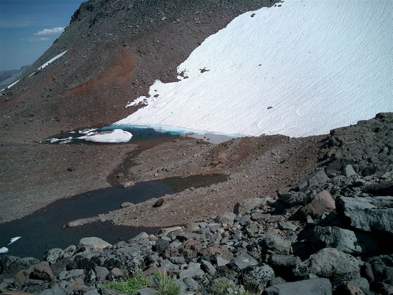 A very blue and very cold pond formed at the base of the glacier